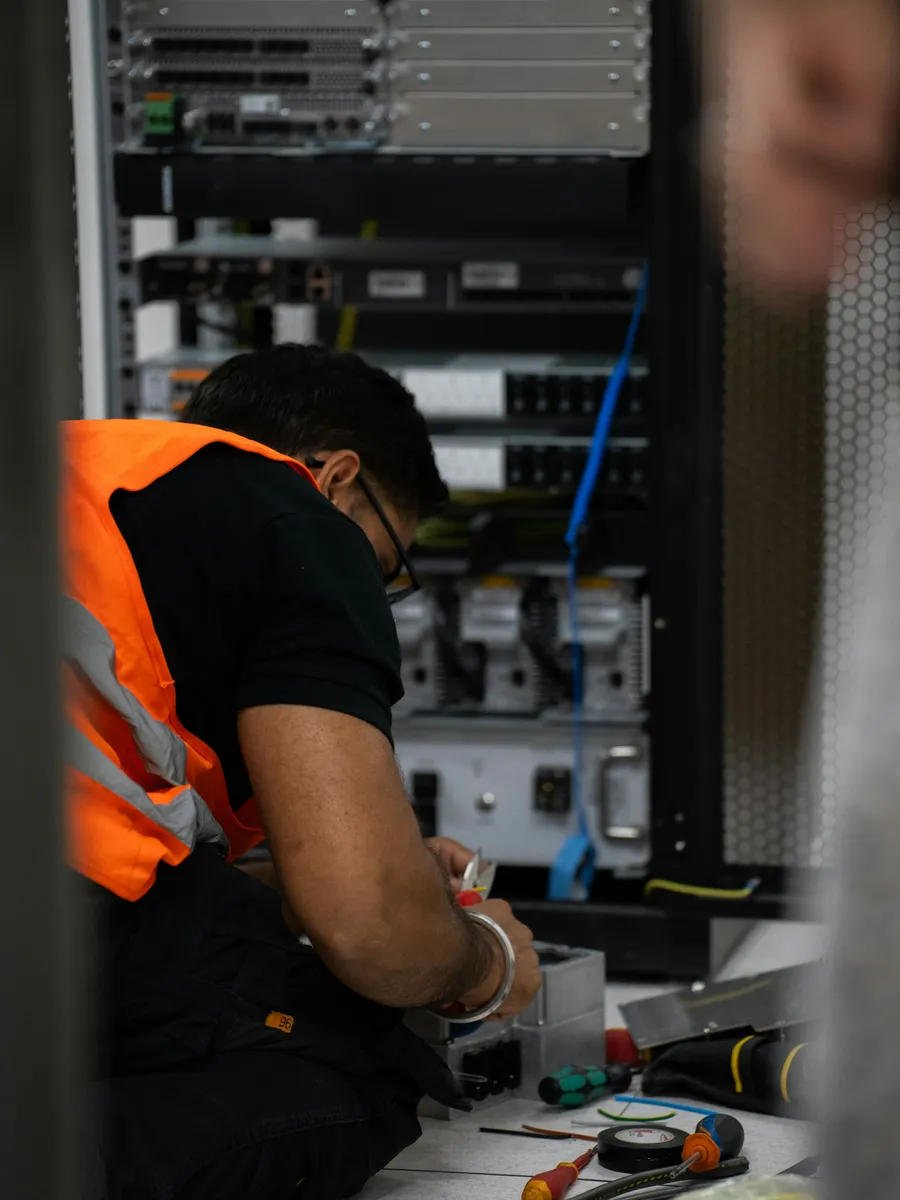 Field technician working on a communications rack